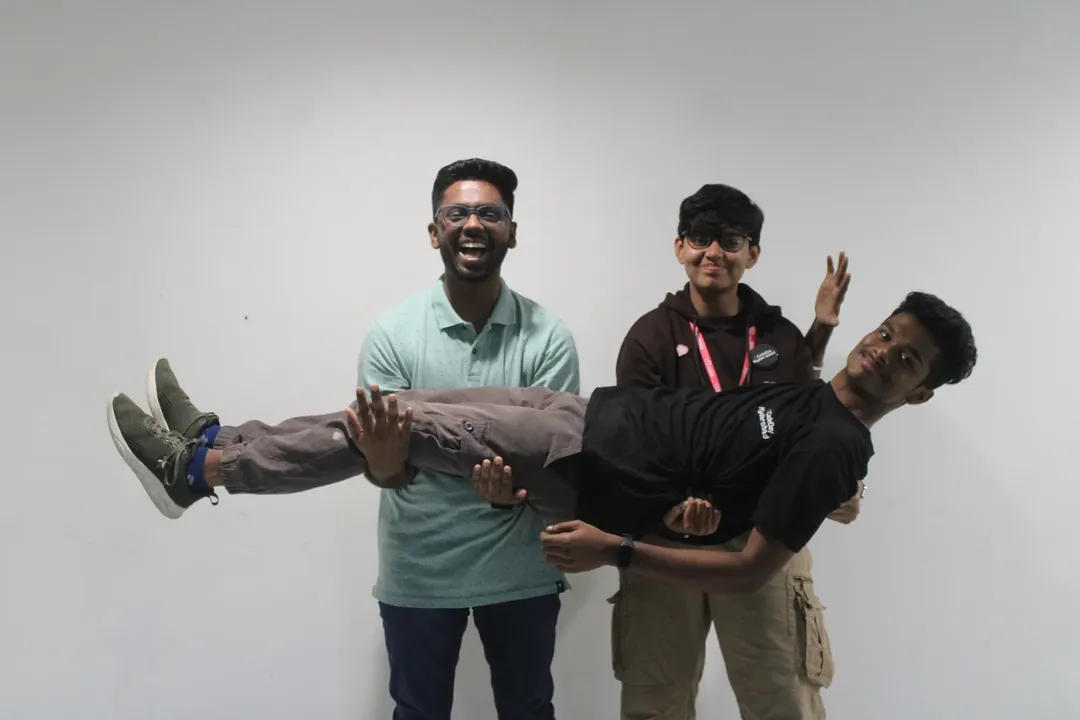 Friends posing together and holding one teammate